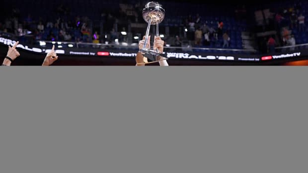 Aces forward A’ja Wilson holds up the WNBA championship trophy with her teammates around her.